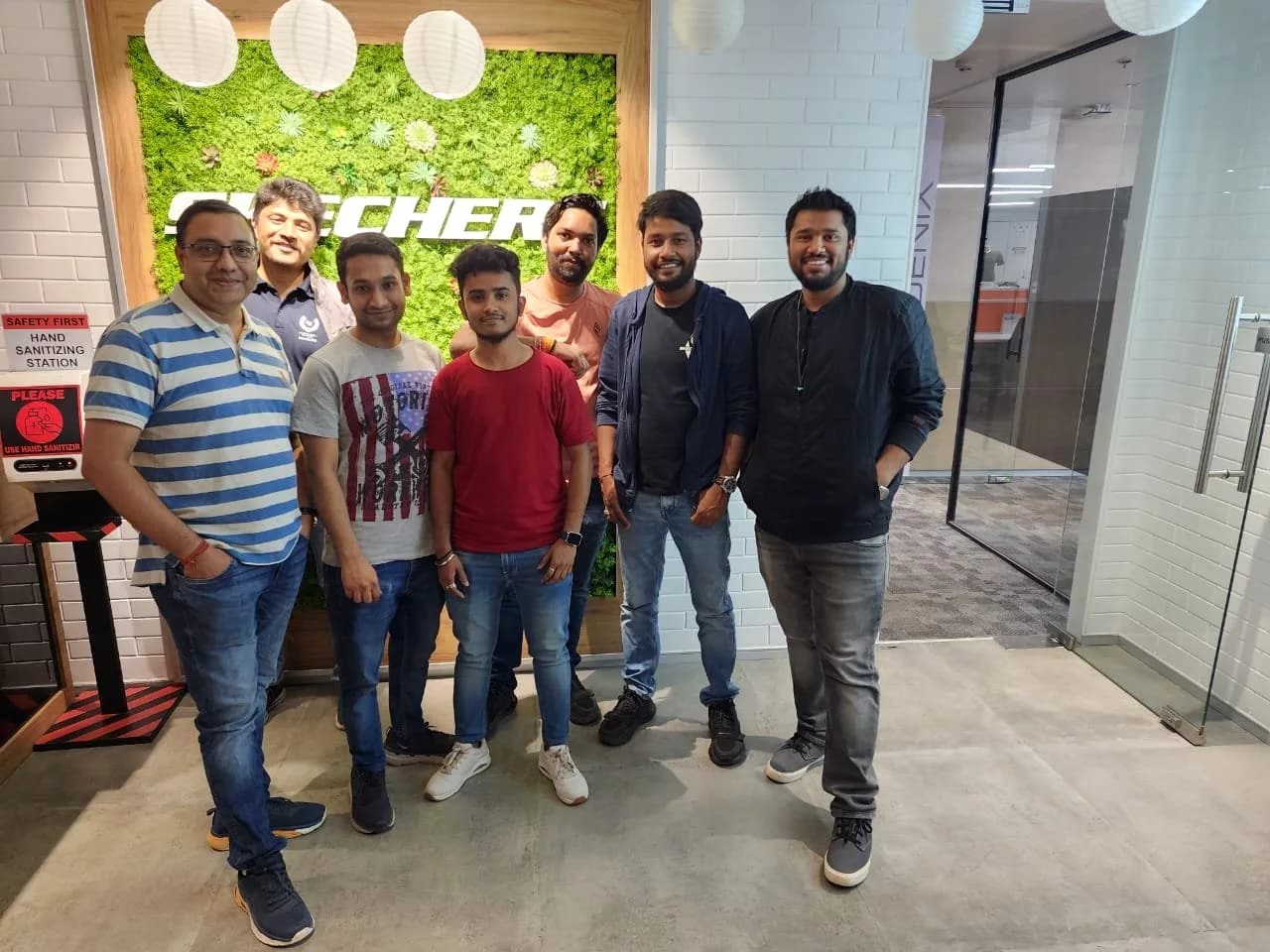 A group of Academy of Retail Excellence students photographed together. Sign visible in the photograph: Skechers.